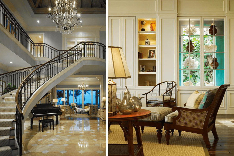 A large staircase underneath a chandelier and two traditional luxurious chairs.