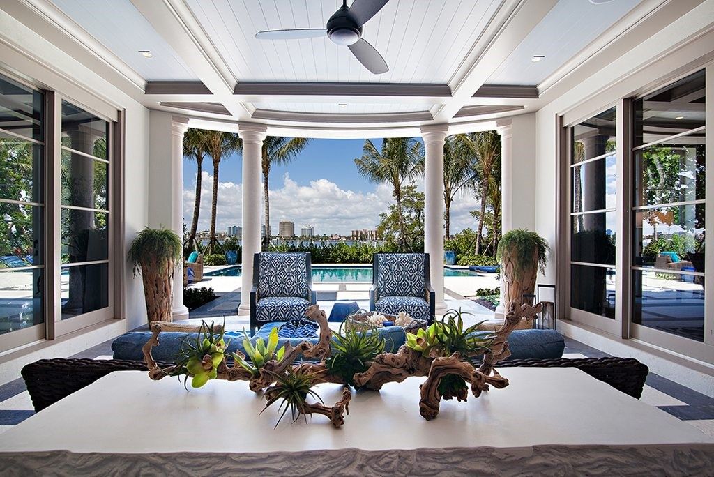 Modern Georgian-Style lakefront outdoor area with a couch and a couple of chairs, in front of a pool.