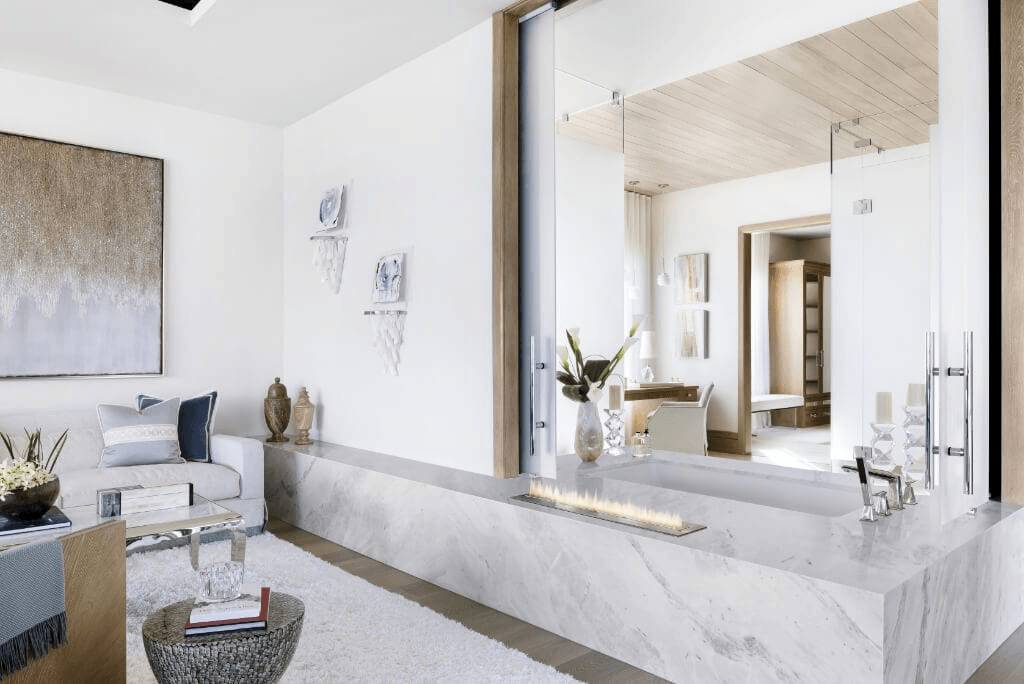 Ocean Ridge contemporary luxury bathroom with a tub surrounded by marble, and a simple fire feature.